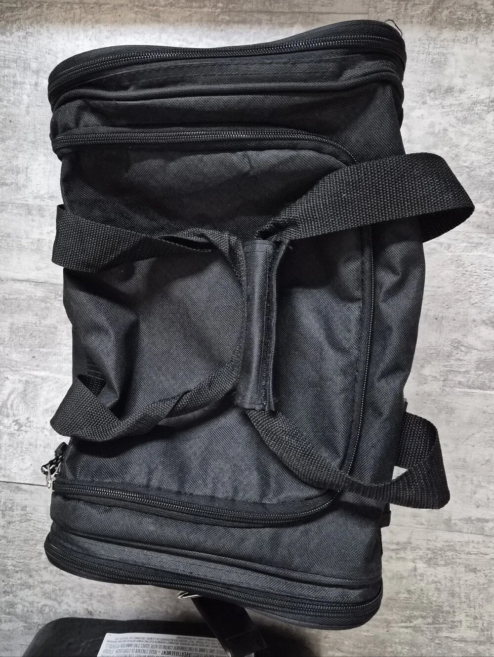 This black Tournamax duffel bag features a prominent logo and secured  pockets
